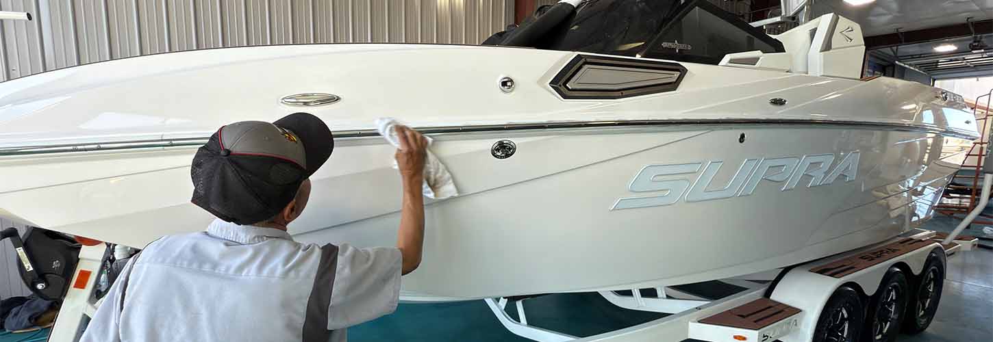 Romoboco Service Department Banner A Rocky Mountain Boat Company Service Technician detailing a white Supra