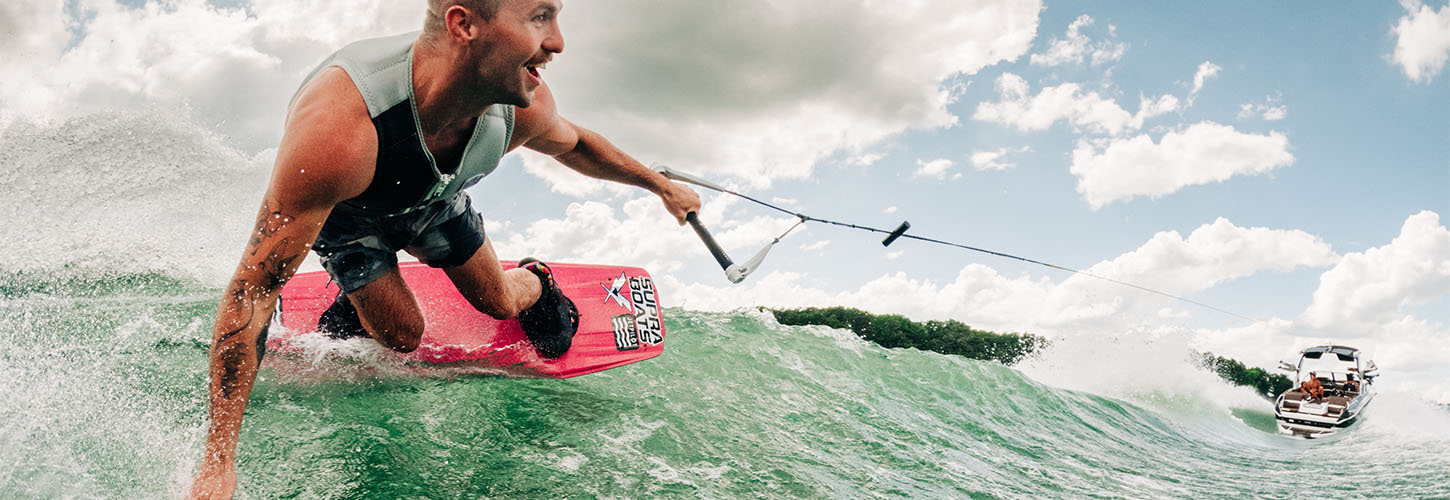 a wakeboarder riding behind a supra boat